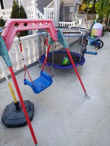 a swing set with a golf ball in a cart at Vila Erjoni in Ksamil
