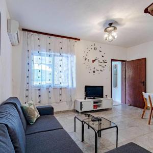 a living room with a blue couch and a tv at Apartmani Mila in Ubli