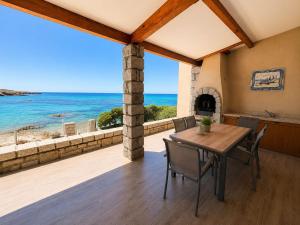 a dining room with a view of the ocean at Villa d'exception sur la plage - Tizzano in Sartène