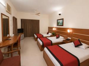 a hotel room with three beds and a desk at Hotel Supreme in Sylhet +32 photos