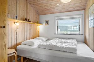 a bedroom with a large bed in a room with a window at LF320-Hurup-Thy-Skraningen-9 in Doverodde