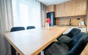 a dining room table with chairs and a vase with flowers at Apartman Lili in Knin