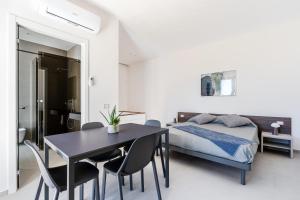 a bedroom with a bed and a table and chairs at Aura - Stagnone Apartments in Marsala