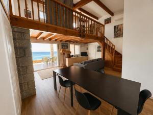 a dining room and living room with a table and chairs at Villa d'exception sur la plage - Tizzano in Sartène