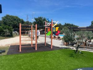 a playground in a park with at Jacuzi Cottage in the olive grove in Pula
