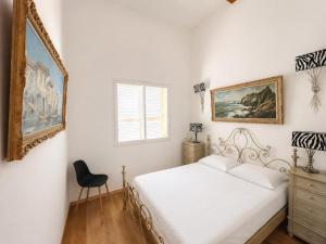 a bedroom with a bed and a mirror and a chair at Villa d'exception sur la plage - Tizzano in Sartène