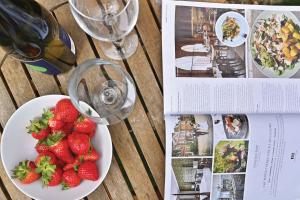 a table with a plate of strawberries and a bottle of wine at Stone's Throw in Hythe