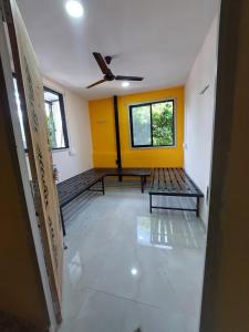 a room with two benches and a yellow wall at UrBan PG&HOSTEL Deluxe Triple Accommodation Boy's Only in Pune