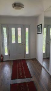 an empty room with doors and a red rug on the floor at Studio privatif DATCHA in Saint-Germain-en-Laye