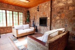 a living room with two couches and a tv at Critchley Common in Dullstroom
