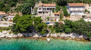 an aerial view of a house on a hill with water at Apartmani Mila in Ubli +13 photos