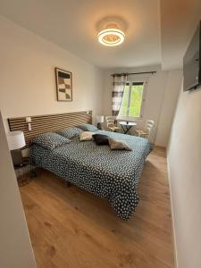 a bedroom with a bed and a table and a window at la Pause Pyrénées in Maubourguet