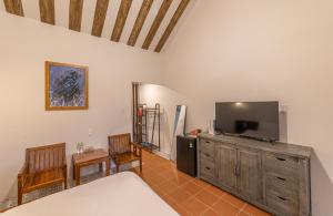 a bedroom with a tv and a bed and chairs at Sunset Valley Dalat in Khu Chi Lăng +83 photos