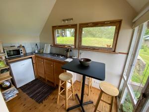 a small kitchen with a black table and a window at The Fishermans Net House in Bigauņciems +16 photos