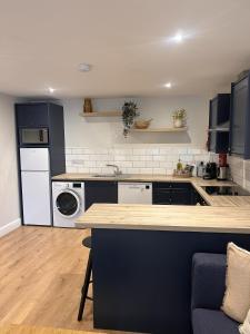 a kitchen with a counter and a washer and dryer at Village Centre Haven in Clifden