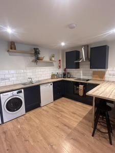 a kitchen with black cabinets and a white dishwasher at Village Centre Haven in Clifden +14 photos