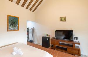 a bedroom with a bed and a flat screen tv at Sunset Valley Dalat in Khu Chi Lăng