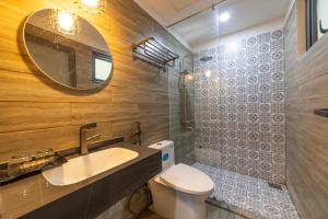 a bathroom with a sink and a toilet and a mirror at Sunset Valley Dalat in Khu Chi Lăng