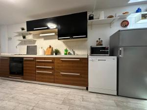 a kitchen with stainless steel appliances and wooden cabinets at Yasmin Breeze Apartment in Nerezine