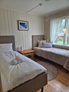 a bedroom with two beds and a window at Apartment, Rekkedal Gjestegard - Sæbø in Ørsta
