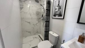 a bathroom with a shower and a toilet and a sink at Duplex Signature - Downtown - Sens in Sens