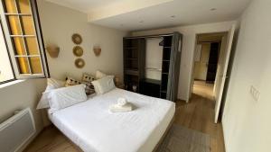 a bedroom with a white bed with a towel on it at Duplex Signature - Downtown - Sens in Sens