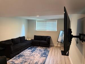 a living room with a couch and a flat screen tv at Cozy ATL Suite with Kitchenette in Atlanta