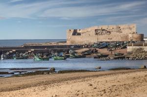 a group of boats in the water in front of a castle at Souiria lakdima in Souira Guedima