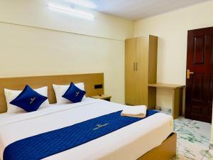 a bedroom with a large bed with blue pillows at Breeza Residency in Kazhakuttam