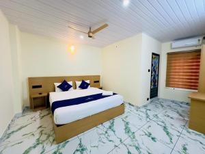 a bedroom with a bed with blue pillows on it at Breeza Residency in Kazhakuttam +2 photos