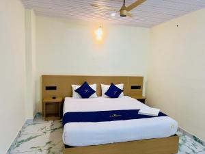 a bedroom with a large bed with blue pillows at Breeza Residency in Kazhakuttam