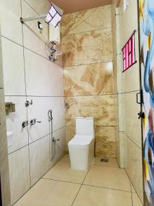a bathroom with a toilet and a shower at Breeza Residency in Kazhakuttam