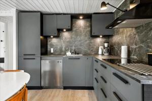a kitchen with stainless steel appliances and gray cabinets at LF15197-Hojslev-Venovej-36 in Højslev +13 photos