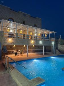 a building with a swimming pool at night at Tigmi berber in Essaouira