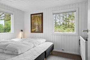 a bedroom with a large bed with two windows at LF15197-Hojslev-Venovej-36 in Højslev