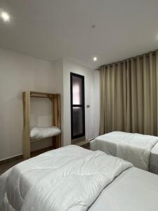 a hotel room with two beds and a mirror at Kili Maisha Grand Home in Moshi