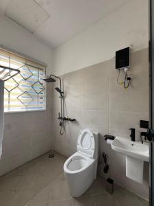 a bathroom with a toilet and a sink at Kili Maisha Grand Home in Moshi +15 photos
