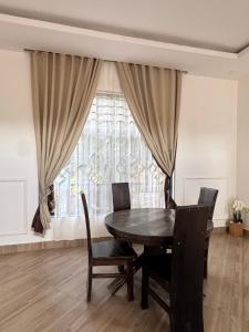 a dining room with a table and chairs and a window at Kili Maisha Grand Home in Moshi