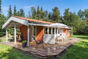 a house with a wooden deck and an umbrella at 10054-Rorvig-Lindegardsvaenget-27 in Rørvig