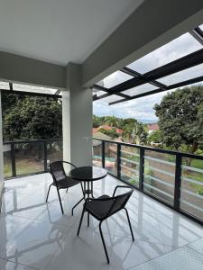 a dining room with a table and chairs and windows at Kili Maisha Grand Home in Moshi