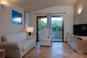 a living room with a couch and a tv at Hotel Nibaru in Porto Cervo