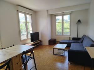 a living room with a couch and a tv at Tréfilerie in Saint-Étienne