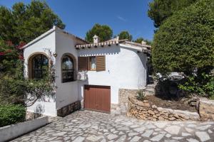 a white house with a gate and a stone driveway at Javea Vedat by Concept Flats in Jávea