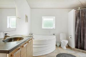 a bathroom with a tub and a sink and a toilet at LF229-Vestervig-Hannesvej-16 in Vestervig +13 photos