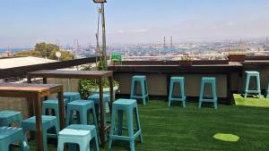 Eine Gruppe blauer Hocker steht auf dem Rasen. in der Unterkunft Hotel Loui Talpiot in Haifa