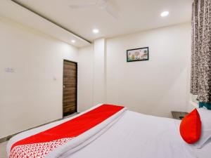 a bedroom with a bed with a red blanket at HOTEL O M J HEIGHTS in Garhā