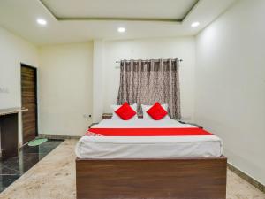 a bedroom with a large bed with red pillows at HOTEL O M J HEIGHTS in Garhā +21 photos