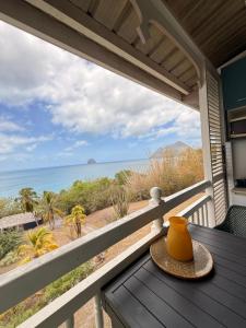 a vase sitting on a table on a porch overlooking the ocean at Studio Vigie 212 vue mer, accès piscine in Le Diamant