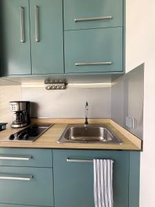 a kitchen with a sink and a stove at Studio Vigie 212 vue mer, accès piscine in Le Diamant
