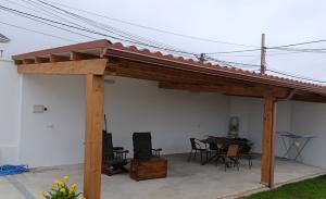 a wooden pavilion with a table and chairs and a table at La casa de Carmen in Neda